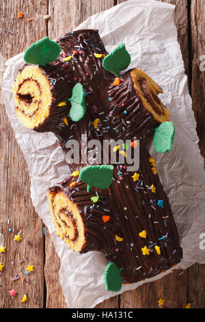 Cioccolato tradizionale Natale rotolo di registro vicino sul tavolo. vista verticale dall'alto. Stile rustico Foto Stock