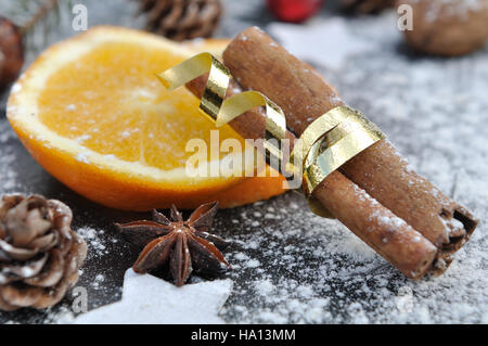 Fettine di arancia e bastoncini di cannella su ardesia coperto dalla farina Foto Stock
