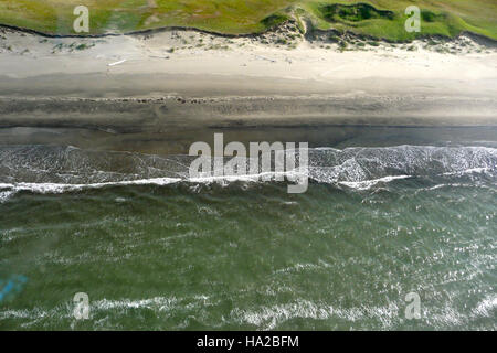 Il Bering Land Bridge, visibile mentre le onde si infrangono sulla costa incontaminata, rappresenta un legame storico tra Asia e Nord America. Questa caratteristica naturale ha un immenso significato geologico e antropologico, che segna una rotta migratoria cruciale nella preistoria. Foto Stock