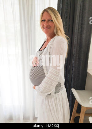 Ritratto di un sorridente donna in stato di gravidanza Foto Stock