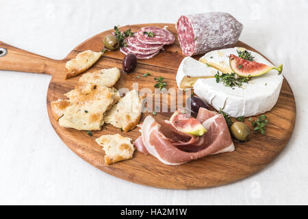 Formaggi e salumi sul tagliere Foto Stock