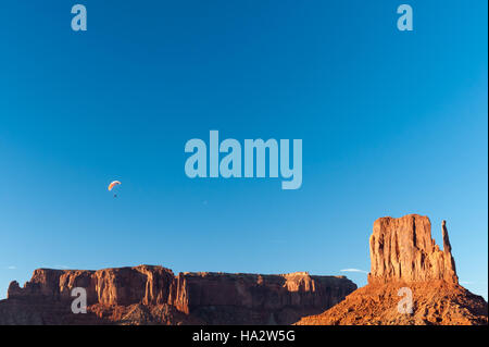 Parapendio sopra Mittens, Monument Valley, Arizona, Stati Uniti Foto Stock