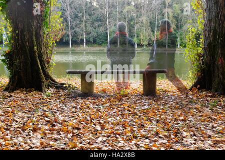 Uomo seduto su una panchina da un fiume, Niort, Francia Foto Stock