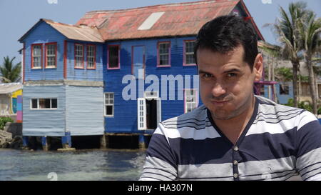L'uomo rendere divertente la faccia e la vecchia casa Foto Stock