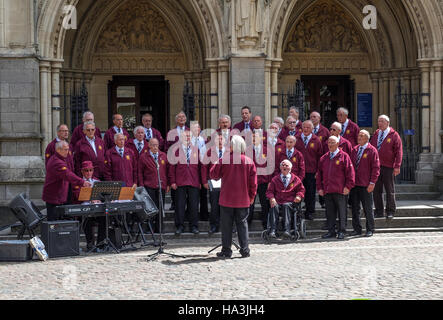 Truro coro di sole voci maschili di eseguire al di fuori della cattedrale di Truro, Cornwall, Regno Unito Foto Stock