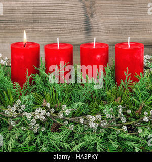 Avvento corona di decorazione con rosso quattro candele accese Foto Stock