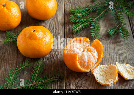 Tangerine e di Abete rami vicino fino oltre il rustico sfondo di legno - odore del tempo di Natale e vacanze invernali al concetto di casa Foto Stock