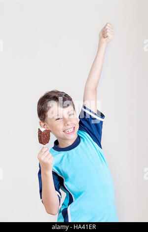 Bambino sentirsi felice con il gelato al cioccolato bar Foto Stock