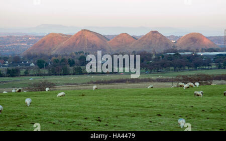 Il sole tramonta sul cinque suore shale bings a west calder, West Lothian. Foto Stock