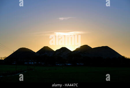 Il sole tramonta sul cinque suore shale bings a west calder, West Lothian. Foto Stock