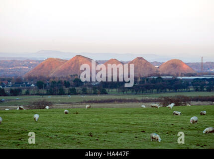 Il sole tramonta sul cinque suore shale bings a west calder, West Lothian. Foto Stock