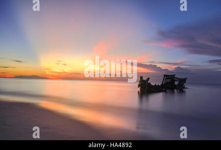 Relitto di nave da pesca in barca sulla spiaggia al tramonto Foto Stock