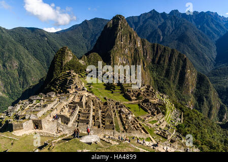 Vista della perduta città Inca di Machu Picchu vicino a Cusco, Perù. Machu Picchu è un peruviano storico Santuario. La gente può essere visto sul primo piano. Foto Stock