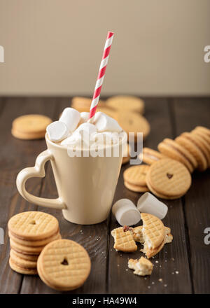 Marshmallows in una tazza con i cookie con i cuori al di fuori dell'inceppamento. Foto Stock