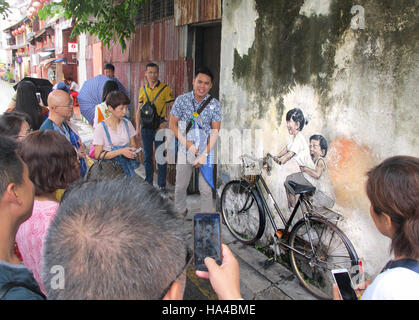 Penang, Malaysia. 10 ottobre, 2016. (FILE) · Un archivio foto, del 10.10.2016, mostra i turisti fotografare la street art di Penang, Malaysia. Il centro storico di George Town in Malesia è elencato come un patrimonio mondiale dell'Unesco ed è particolarmente popolare con i visitatori, non ultimo a causa dell'arte di strada. Foto: Bill Bredesen/dpa/Alamy Live News Foto Stock