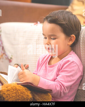 Grazioso fanciullo ragazza della lettura della Bibbia Foto Stock