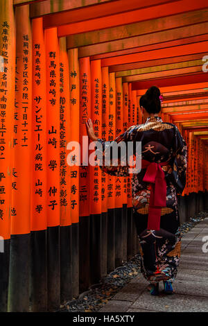 La donna non identificato in passerella a Fushimi Inari shrine in Kyoto, Giappone. Foto Stock
