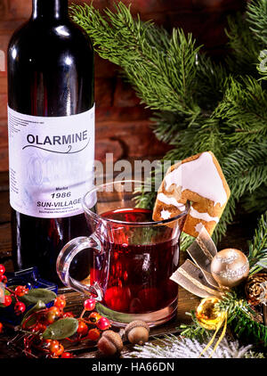 Bottiglia con etichetta di rosso vino caldo e mug . Foto Stock