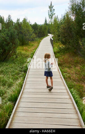 Bambino bimba bionda esplorando la natura a tre lago Moro (stecca Trijezerni), parco nazionale Sumava, foresta Boema, Czech Repu Foto Stock