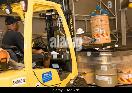 Questa immagine raffigura la preparazione dei tamburi per la spedizione nell'ambito di operazioni legate all'energia all'interno di un parco nazionale, concentrandosi sulla logistica delle attrezzature mobili necessarie per la gestione o la conservazione dell'energia. Il processo è fondamentale per sostenere le iniziative ambientali e mantenere l'efficienza operativa. Foto Stock