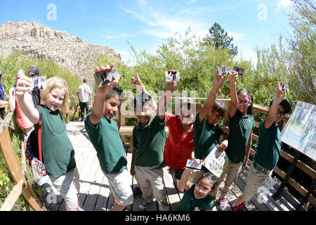 20953181218 blmnevada Segretario Sally Jewell con gli studenti mostrando loro nuove schede Foto Stock