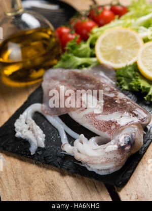 Calamari freschi serviti su una piastra di ardesia Foto Stock