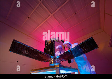 Uno scienziato del Los Alamos National Laboratory osserva la sua riflessione mentre lavora sul satellite Cibola. L'immagine illustra l'ambiente high-tech del laboratorio in cui gli scienziati contribuiscono ai progressi nell'esplorazione spaziale. Il progetto satellitare Cibola fa parte degli sforzi volti a migliorare la tecnologia satellitare e le conoscenze scientifiche. Foto Stock