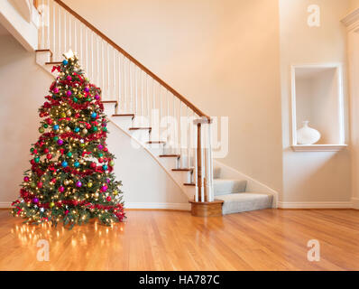 Completamente decorato di Natale sul pavimento in legno con scala in background Foto Stock