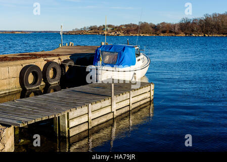 Tjurko, Svezia - 24 Novembre 2016: Travel documentario di piccolo locale marina in caduta. Un motoscafo ormeggiato procedure Dockside Wizard e l'arcipelago visibile in Foto Stock