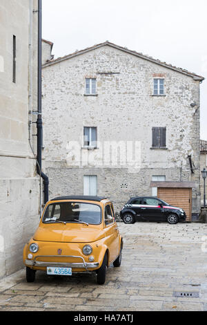 Il vecchio e il nuovo. La Fiat Cinquecento è ideale per le strette strade di San Marino, Italia. In fondo è un nuovo modello di veicolo iconica. Foto Stock