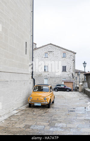 Il vecchio e il nuovo. La Fiat Cinquecento è ideale per le strette strade di San Marino, Italia. In fondo è un nuovo modello di veicolo iconica. Foto Stock