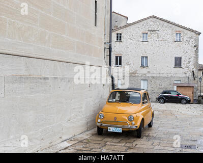 Il vecchio e il nuovo. La Fiat Cinquecento è ideale per le strette strade di San Marino, Italia. In fondo è un nuovo modello di veicolo iconica. Foto Stock