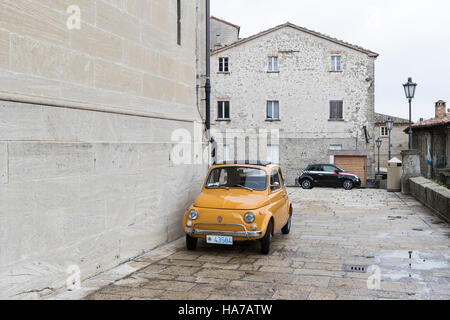 Il vecchio e il nuovo. La Fiat Cinquecento è ideale per le strette strade di San Marino, Italia. In fondo è un nuovo modello di veicolo iconica. Foto Stock