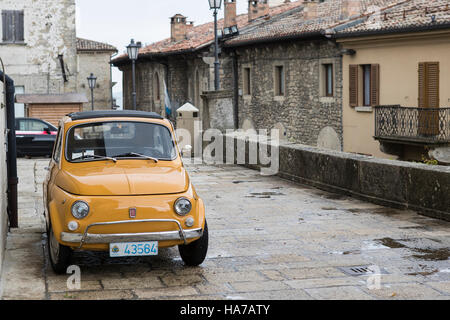 Il vecchio e il nuovo. La Fiat Cinquecento è ideale per le strette strade di San Marino, Italia. In fondo è un nuovo modello di veicolo iconica. Foto Stock