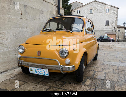 Il vecchio e il nuovo. La Fiat Cinquecento è ideale per le strette strade di San Marino, Italia. In fondo è un nuovo modello di veicolo iconica. Foto Stock