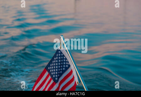 Dettaglio immagine di una bandiera americana su un acciaio inossidabile pole con acqua salata in background Foto Stock