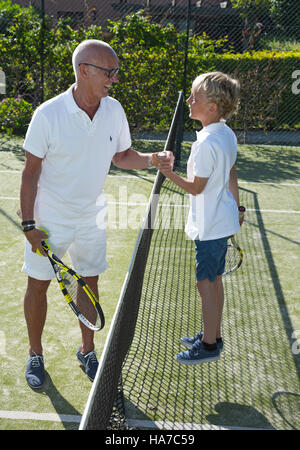 Nonno e nipote giocando a tennis insieme. Foto Stock