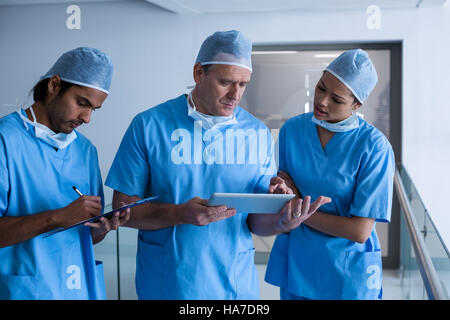 Il team di chirurghi a discutere su tavoletta digitale Foto Stock