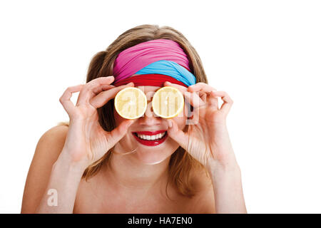 Giovane donna con colorati stringitesta tenendo i limoni di fronte ai suoi occhi Foto Stock