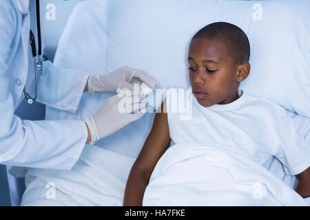 Medico donna dando una iniezione di un paziente Foto Stock