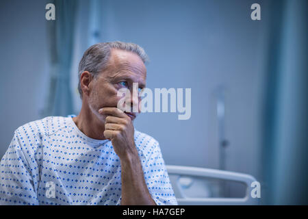 Malato seduta sul letto Foto Stock
