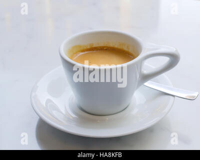 White tazza di espresso su marmo bianco superficie, decorato con un cucchiaio Foto Stock