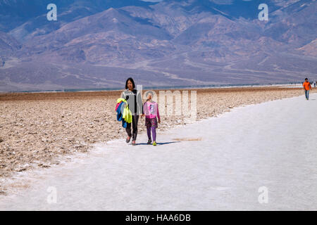 Madre e figlia a piedi nel bacino di sale, bacino Badwater, Parco Nazionale della Valle della Morte, CALIFORNIA, STATI UNITI D'AMERICA Foto Stock