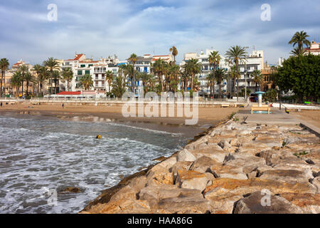 In Spagna, in Catalogna, Sitges, città costiera al Mar Mediterraneo, la spiaggia e la skyline da un molo Foto Stock