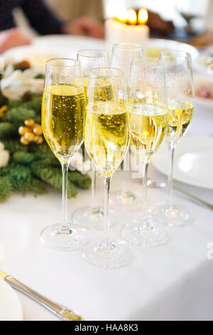 Champagne in un bicchieri in piedi sulla tavola del Natale. Close up Foto Stock