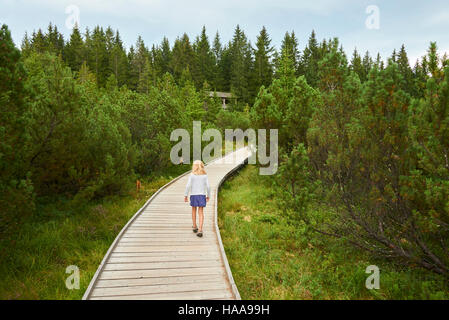 Bambino bimba bionda esplorando la natura a tre lago Moro (stecca Trijezerni), parco nazionale Sumava, foresta Boema, Czech Repu Foto Stock