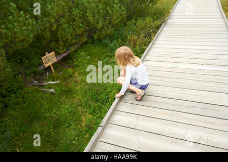 Bambino bimba bionda esplorando la natura a tre lago Moro (stecca Trijezerni), parco nazionale Sumava, foresta Boema, Czech Repu Foto Stock