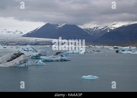 Iceberg sulla laguna di Jokulsarlon, con grande ghiacciaio in background, Vatnajokull National Park, sud est dell'Islanda. Foto Stock