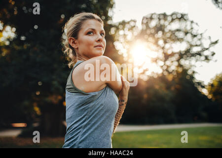 Ritratto di giovane e bella donna che esercitano nel parco. Femmina caucasica modello fitness lavoro fuori al mattino. Foto Stock