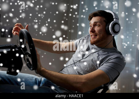 L'uomo gioca car racing video gioco a casa Foto Stock
